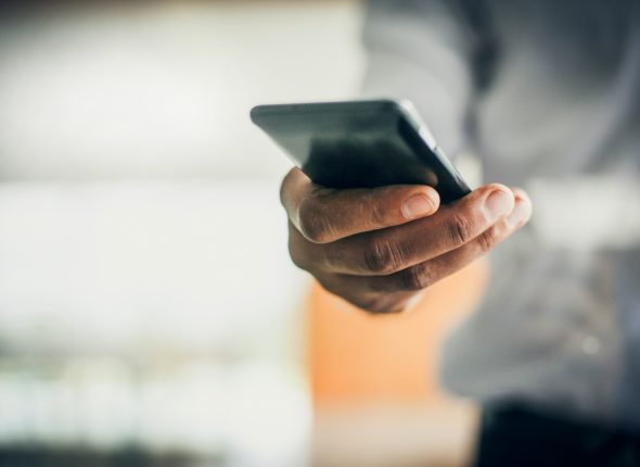 Close up of human hand holding smart phone. Business people.